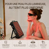 Femme avec lunettes de protection utilisant le panneau REGAIN pour un soin du visage à la lumière rouge